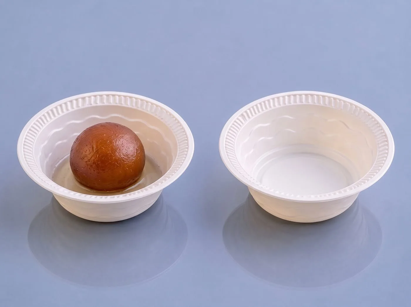 Eco Tray Round Cornstarch Bowl, code 7002, one holding a gulab jamun, one empty