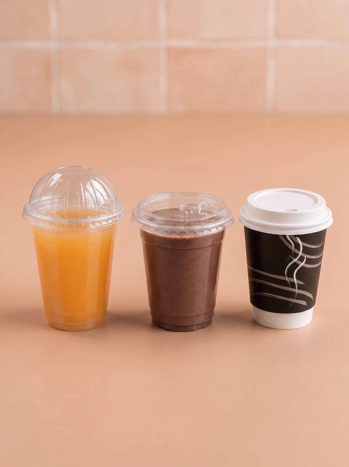 Oracle Group cups fitted with dome and flat lids, holding juice, a cold drink and coffee