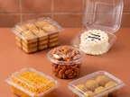 Clear Oracle PET hinged boxes holding biscuits, a birthday cake, nuts, namkeen and laddoos