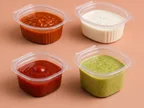 Four clear Oracle PET sauce containers holding chutneys, raita and sauce